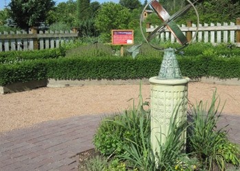 in the Herb Garden in summer at Reiman Gardens with formal planting beds and a sundial
