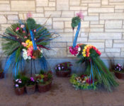floral arrangement in the shape of two peacocks with roses, grasses and feathers