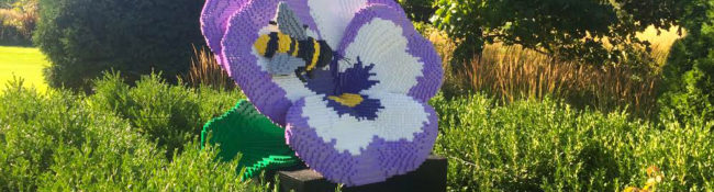 sculpture exhibit of a large sculpture that looks like a pansy that is made of lego bricks