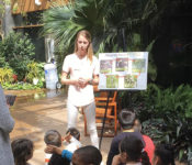 Reiman Gardens intern leading a youth tour with children sitting on the ground