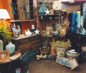 indoors at a botanicl garden outside a gift shop with items for sale like clothes, purses, lamps and home decor.