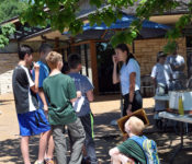 Group gathered outside for Pollinator Fest event with bees and beehives