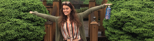 Reiman Gardens intern smiling with her arms in the air