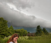 outdoors in summer with somebody walking at the Gardens with large storm clouds behind