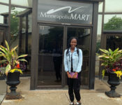 Reiman Gardens interns smiling outside a gif shop mart