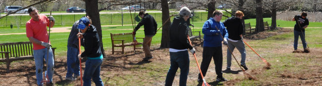 group of volunteers raking outdoors in the early spring in bald cypress allee