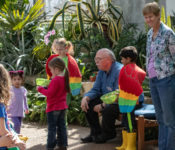 two adult volunteers with a group of children doing an educational activity together