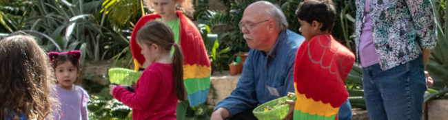 two adult volunteers with a group of children doing an educational activity together
