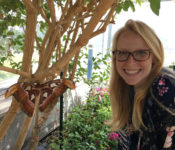enotmology intern posing with a moth in the butterfly wing