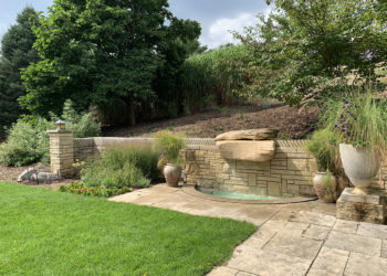 outdoors in summrer in the Outdoor Living Room with grass, plants, a planted container and a water feature