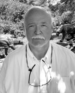 black and white image of a man looking directly into the camera